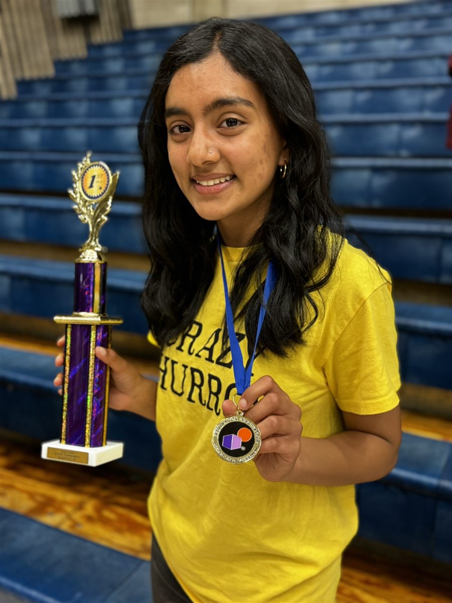 Neti holding a Destination Imagination trophy