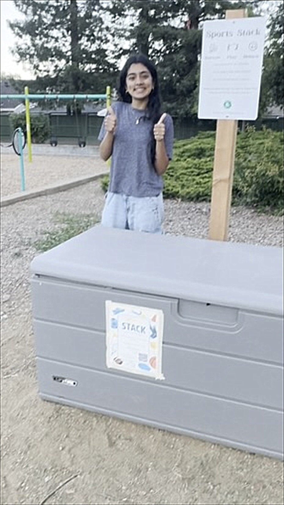 Neti giving two thumbs up next to the Sports Stack box at the park