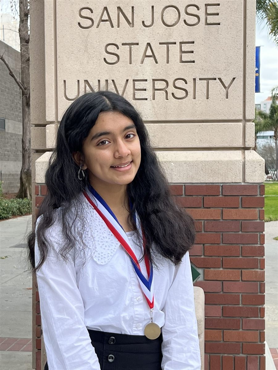 Neti in front of the San Jose State University sign for the Bay Area Honor Choir program